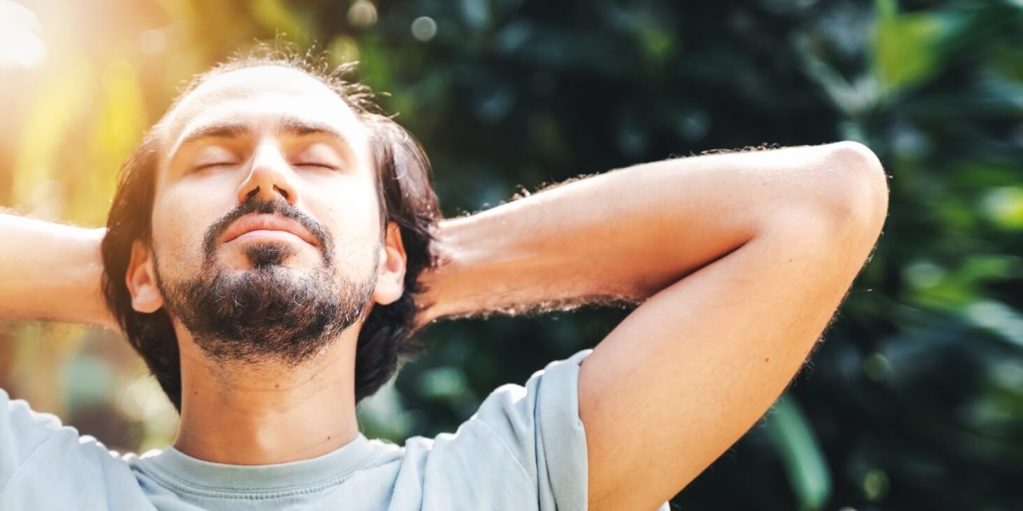 A bearded man is meditating outdoor in the park with face raised Lack of Sexual Confidence